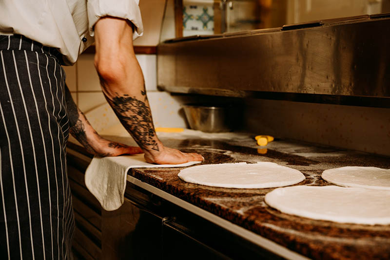 Chef working with a pizza dough in Ravitnola Sergios