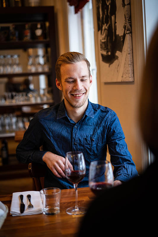 Man smiling and glass of red wine
